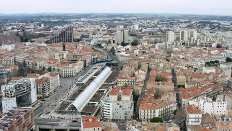 Flying-around-Montpellier-train-station-aerial-view.-Tramway-arriving-in-city